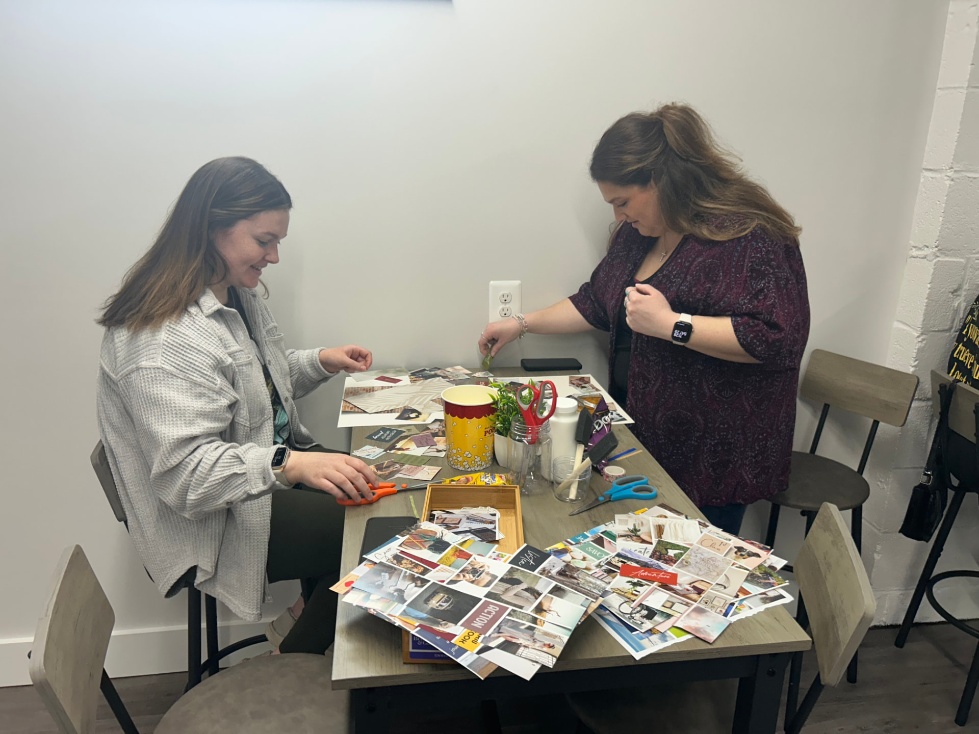 Two grown-ups creating a collage together at a Grown-up Wonder Night table