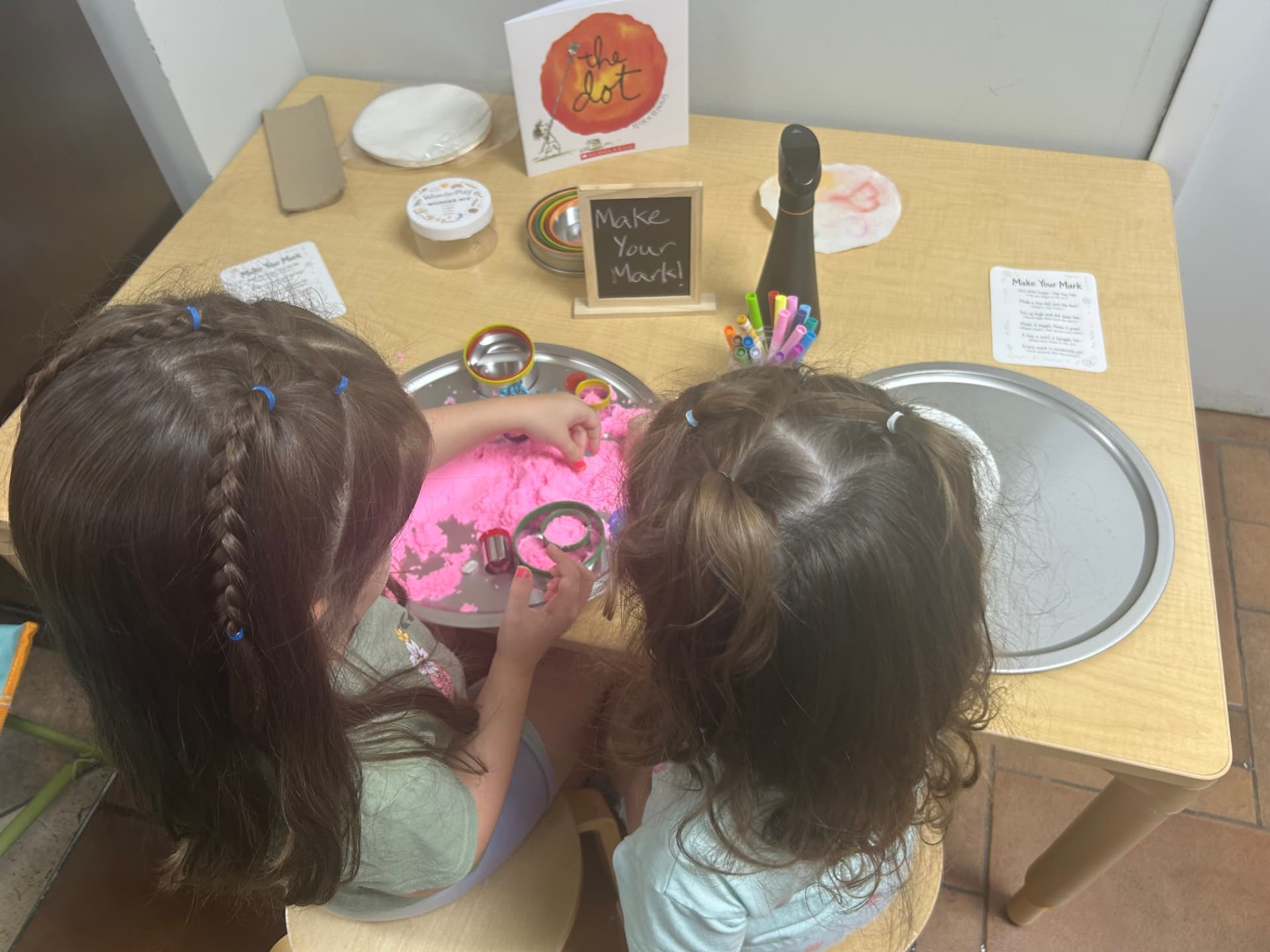 Children exploring pink sensory dough at a WonderPlay table inspired by The Dot