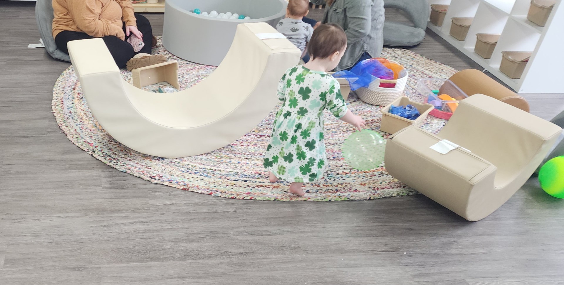 A toddler exploring soft play shapes and a ball pit in a WonderPlay play space